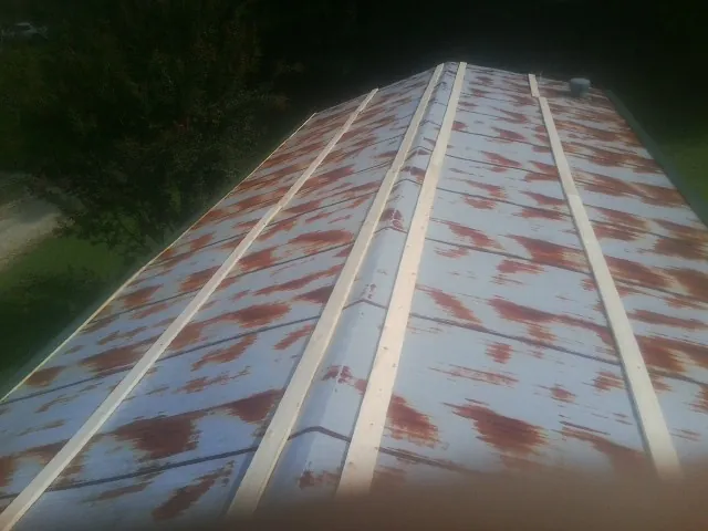 Rusted metal roof panels with new wood purlins before replacement — Storm Damage Roof Repair in Hadlyme by Roofing Brothers