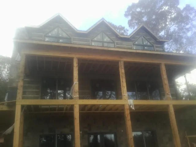 Dormers and porch framing on a large log home under construction — Roof Coating work by our crew in Hadlyme