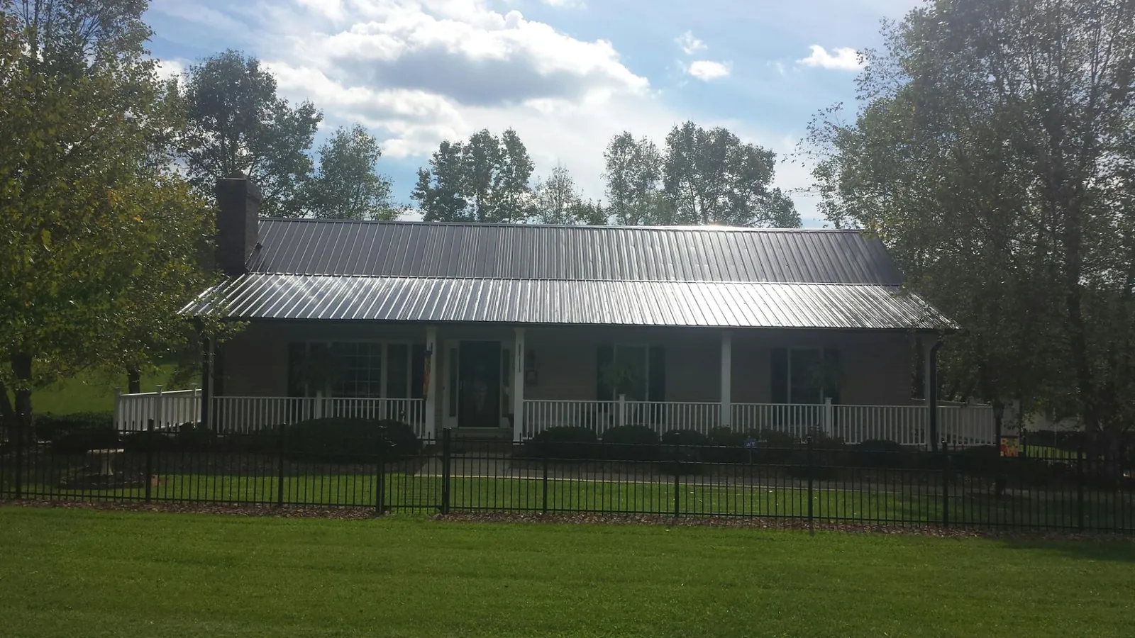 Gray metal roof on a brick ranch with a full width front porch — Gutter Guard Installation work by our crew in Hadlyme