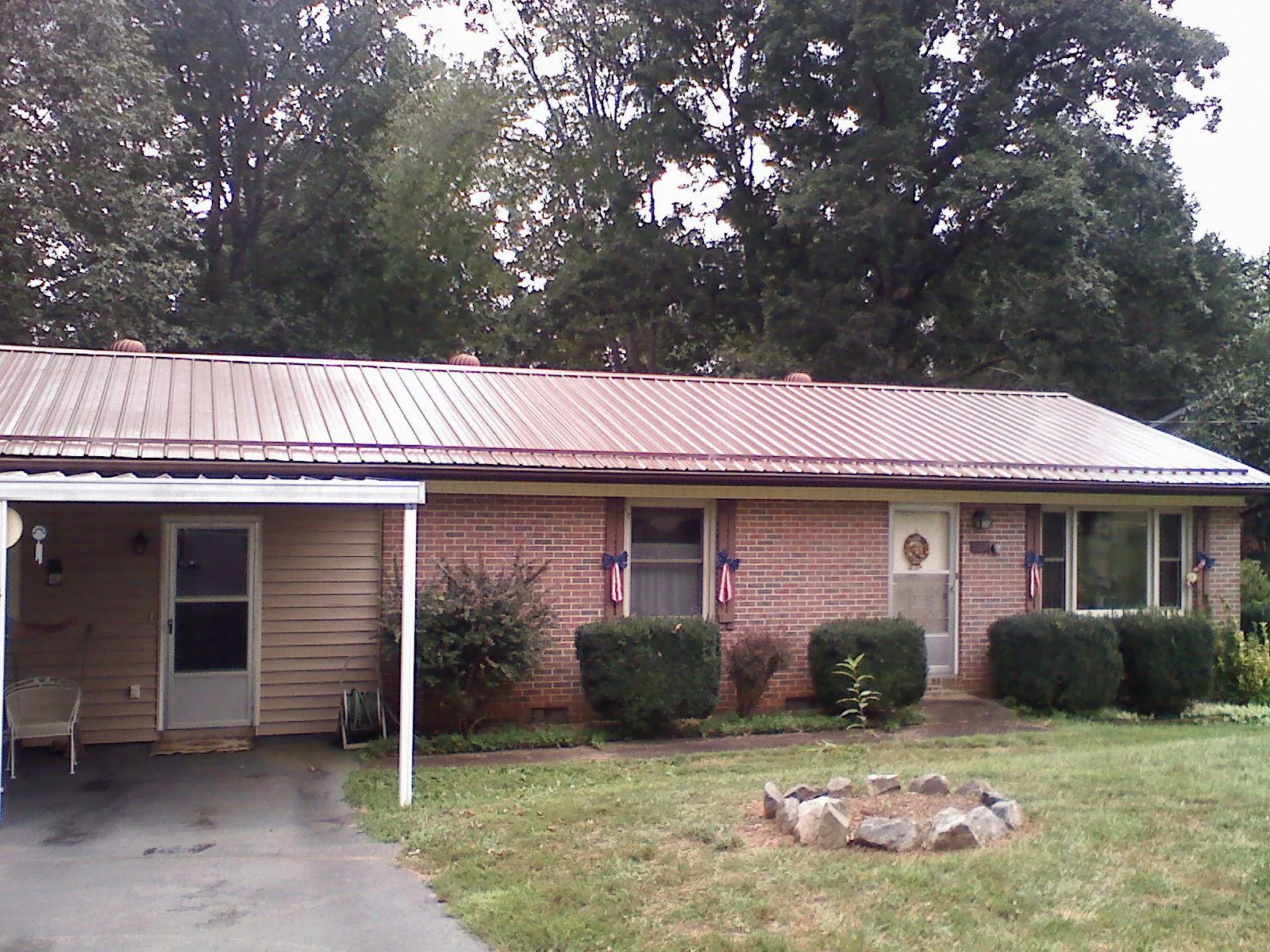 Bronze metal roof and carport on a brick ranch home — Roof Repair work by our crew in Hadlyme